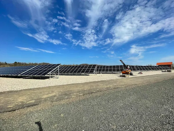 Solarne ploče na ravnom terenu sa bagerom.